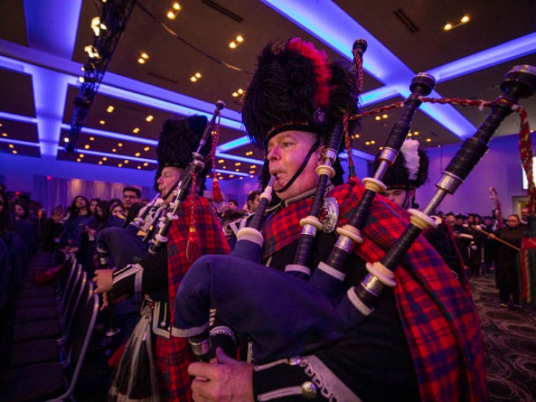 Two people in Scottish attire play the bagpipes