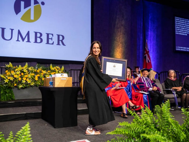 Chantal Kreviazuk holds her framed degree and smiles