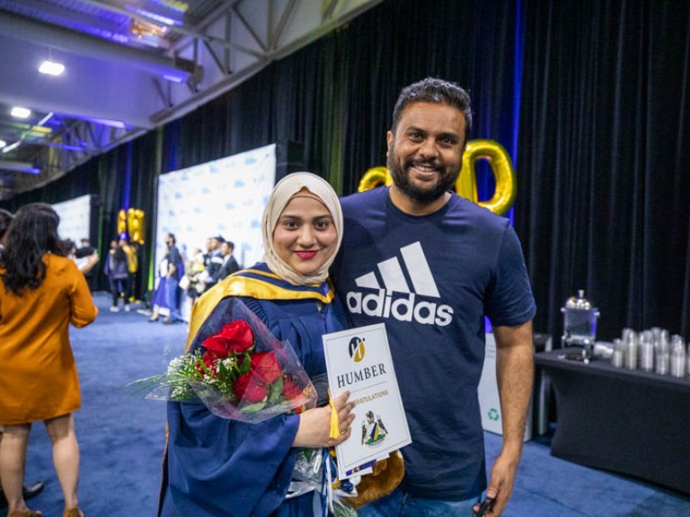 Graduate and guest pose for photo