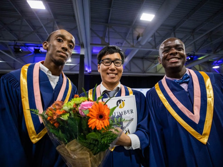 Three graduates pose for camera