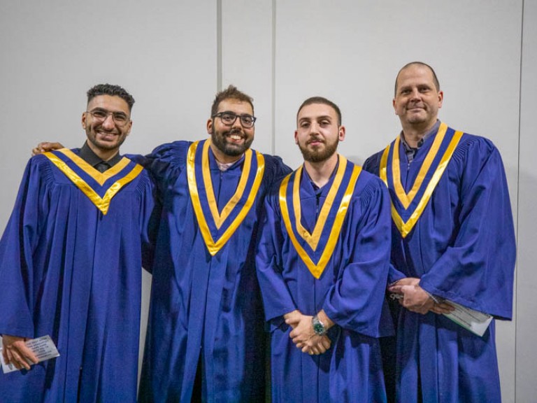 Four graduates pose for camera
