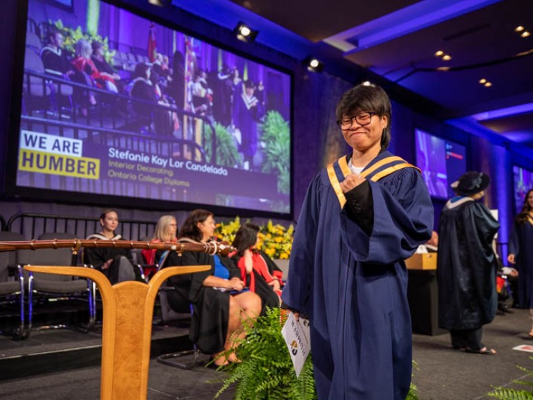 Graduate fists pumps in celebration as they cross stage