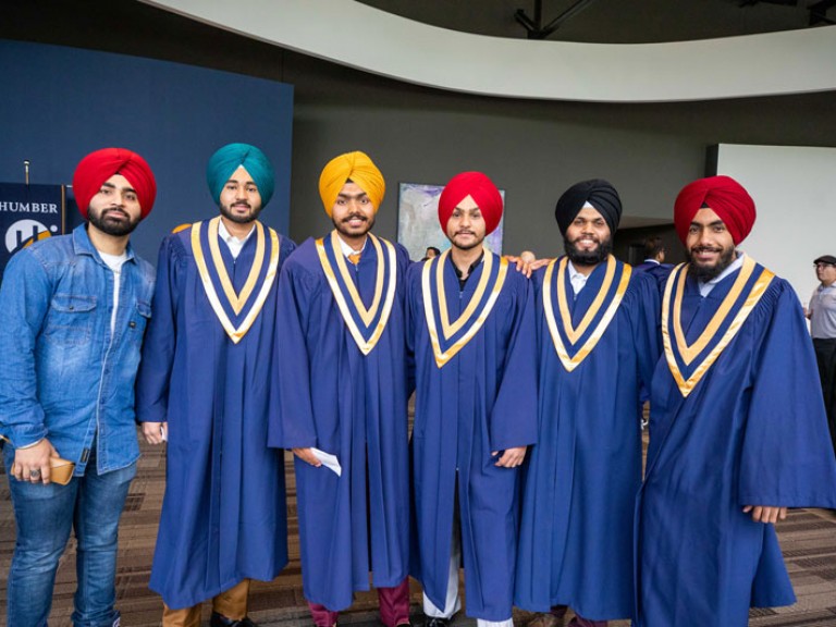 Five graduates and guest pose for photo