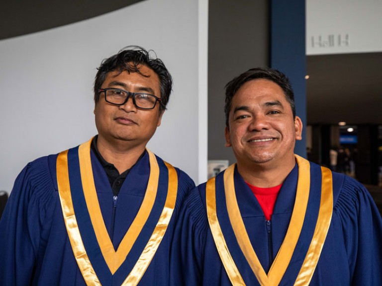 Two graduates pose for camera