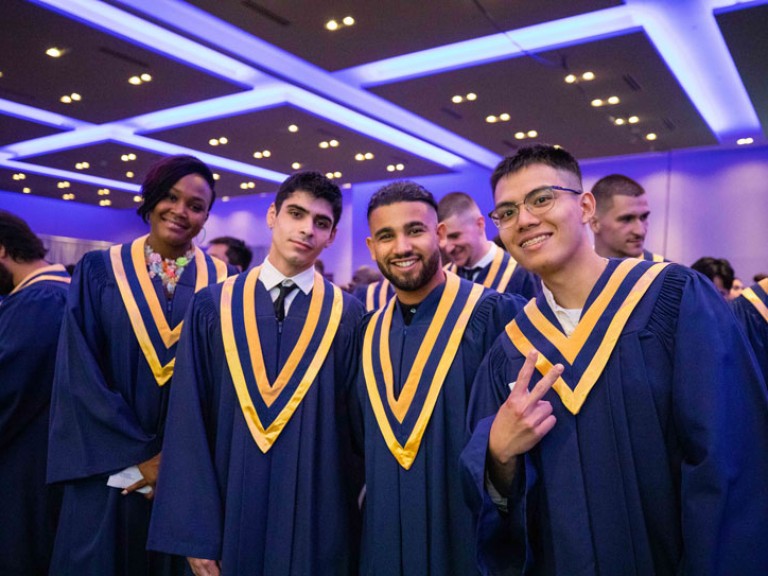 Four graduates pose for photo 