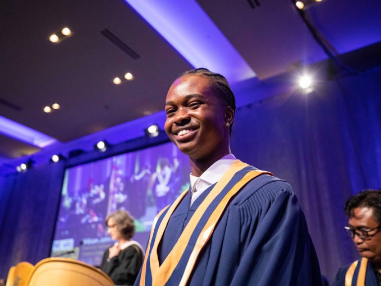 Graduate smiles at camera