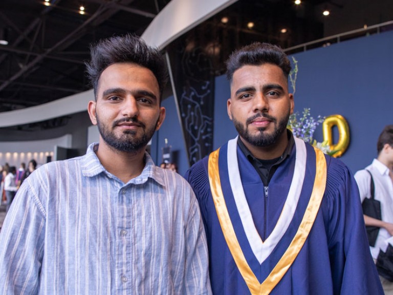 Graduate posing beside a ceremony guest