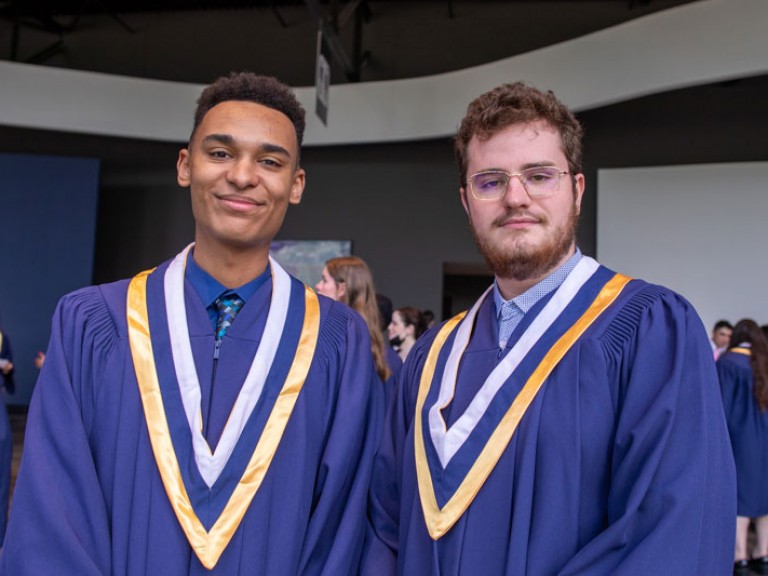 Two graduates pose for photo