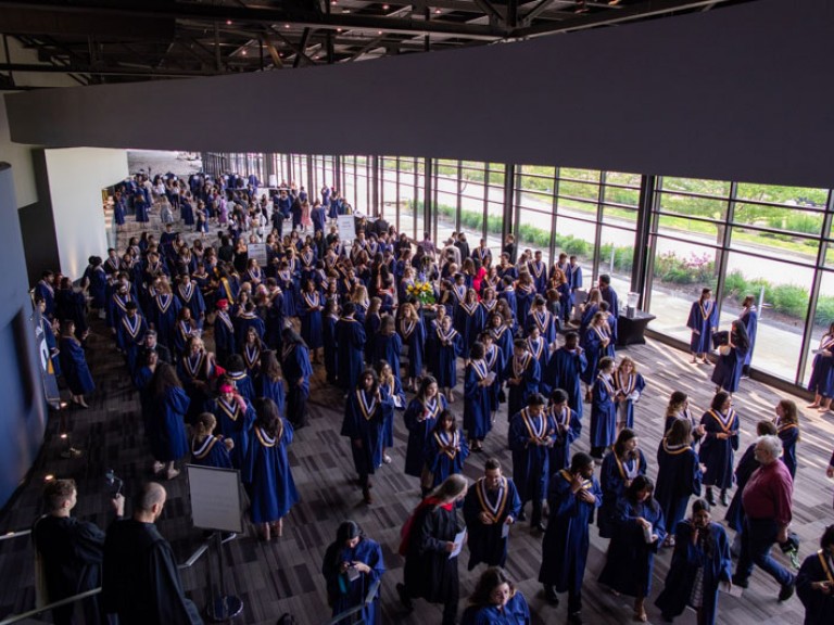 Overhead view of ceremony reception area filled with graduates in gowns