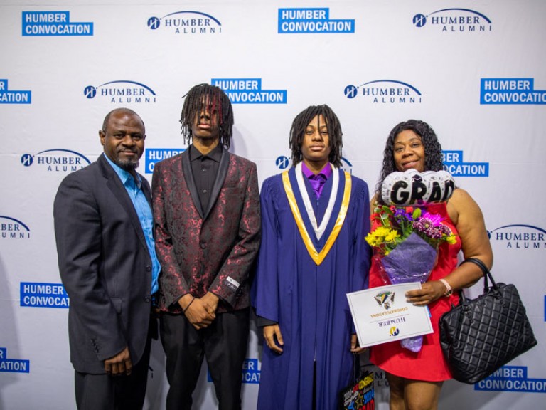 Graduate with three family members pose for photo