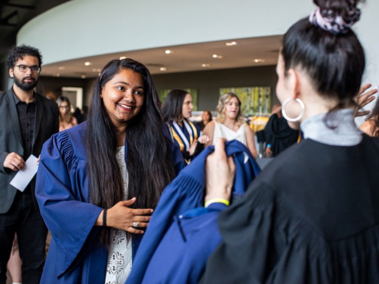 Graduate smiling at someone in reception area