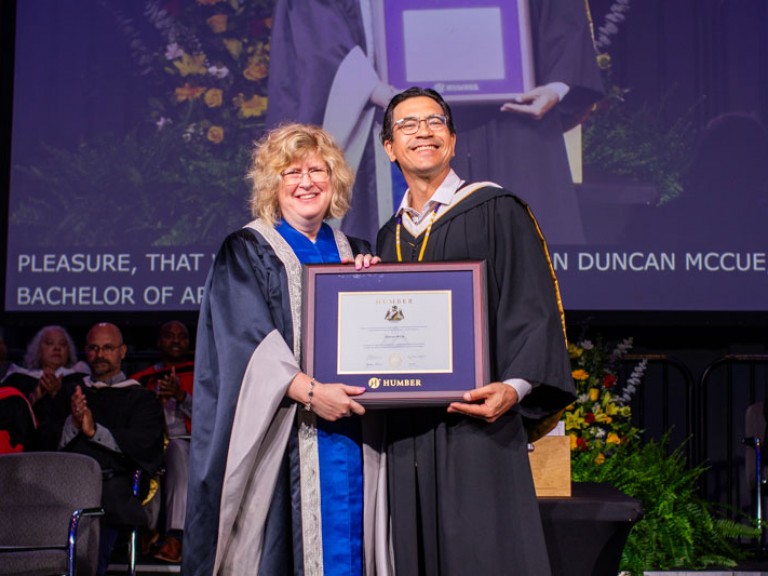 Humber president Ann Marie Vaughan holding degree with honorary degree recipient