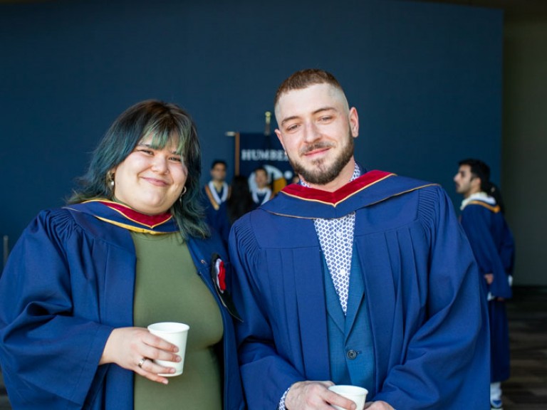 Two graduates pose for photo