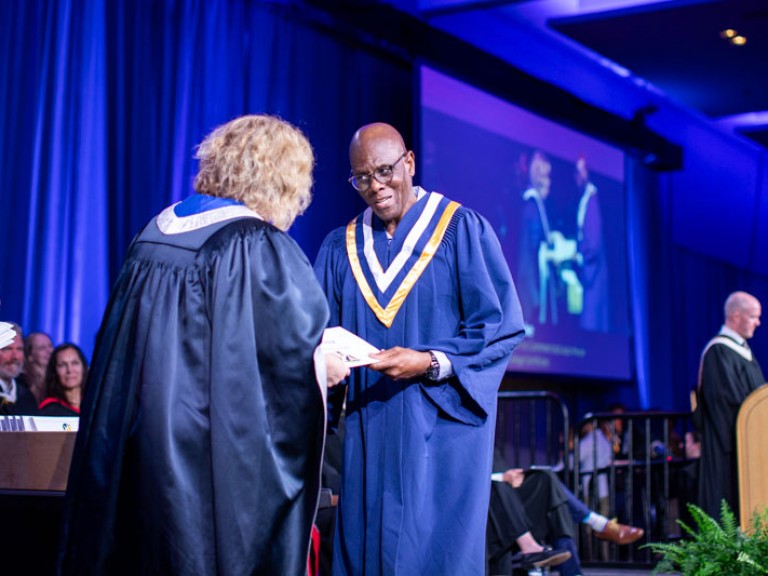 Graduate accepts certificate from Humber President