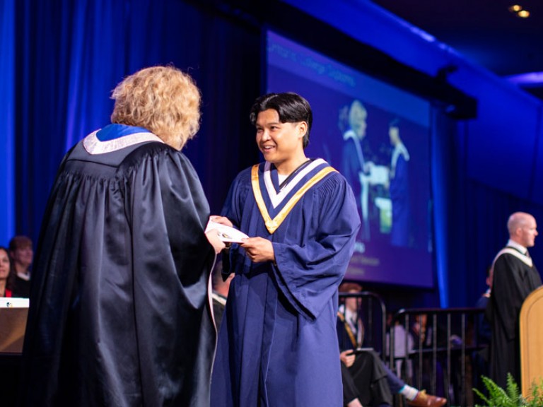 Graduate on stage accepts certificate