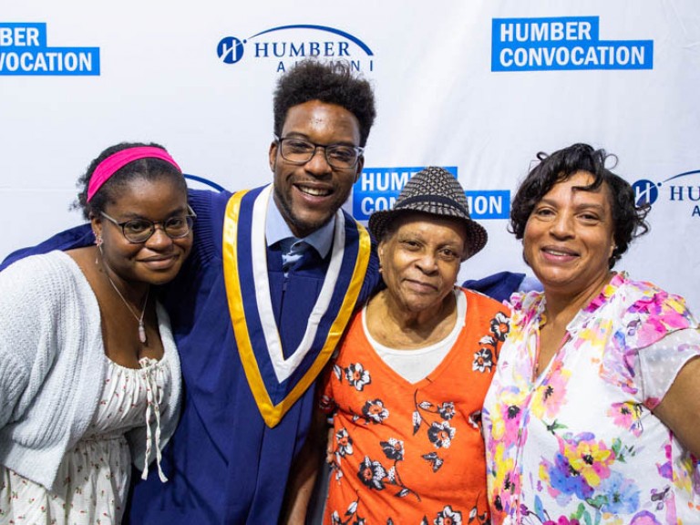 Graduate takes photo with three family members