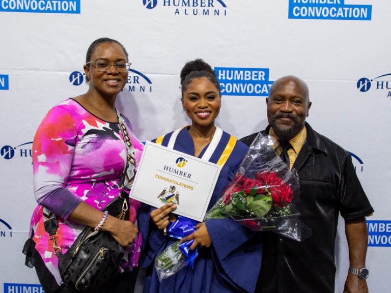 Graduate takes photo with their parents
