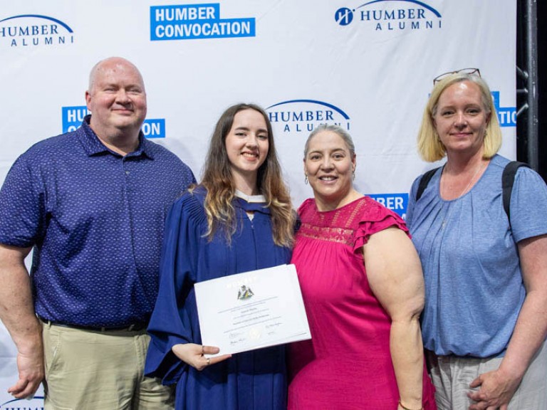 Graduate takes photo with three family members