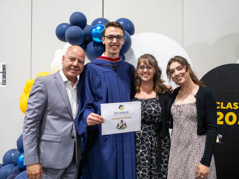 Graduate takes photo with three family members