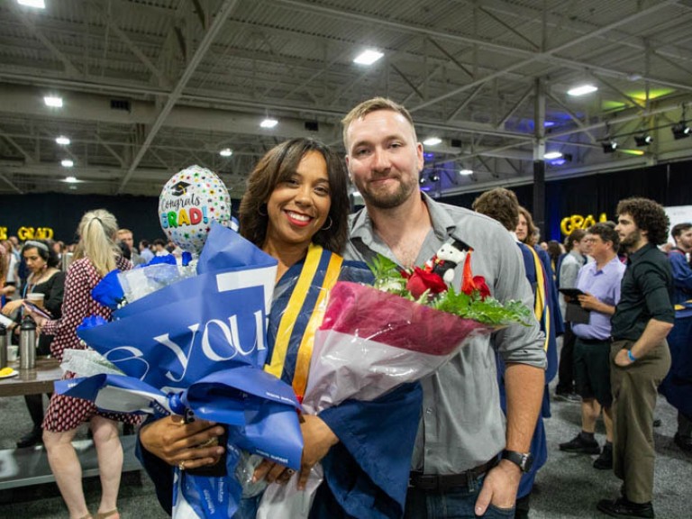 Graduate takes photo with ceremony guest