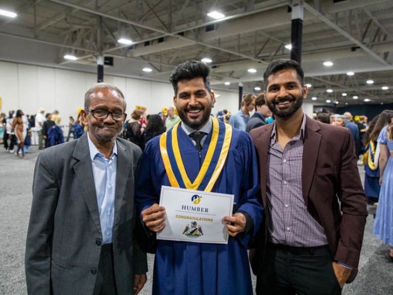 Graduate takes photo with two others