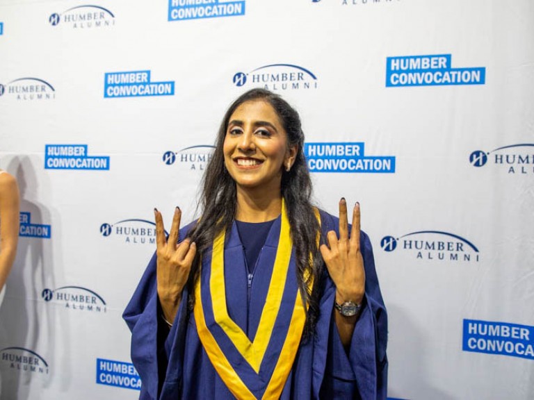 Graduate holds up peace signs
