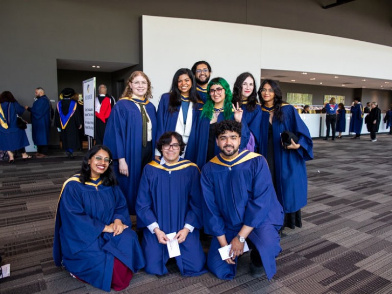 Nine graduates posing for photo