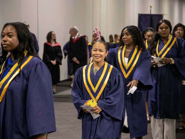 Graduate in line smiles at camera