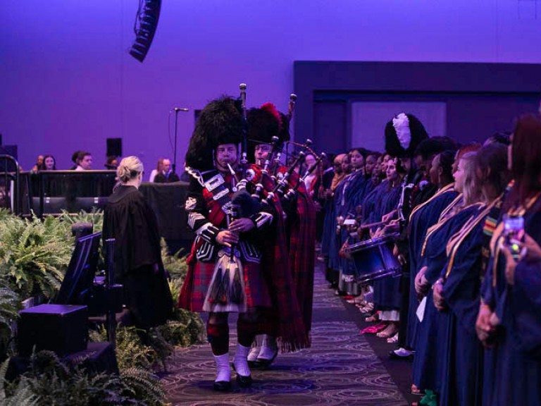 Bagpipe players proceed in ceremony hall