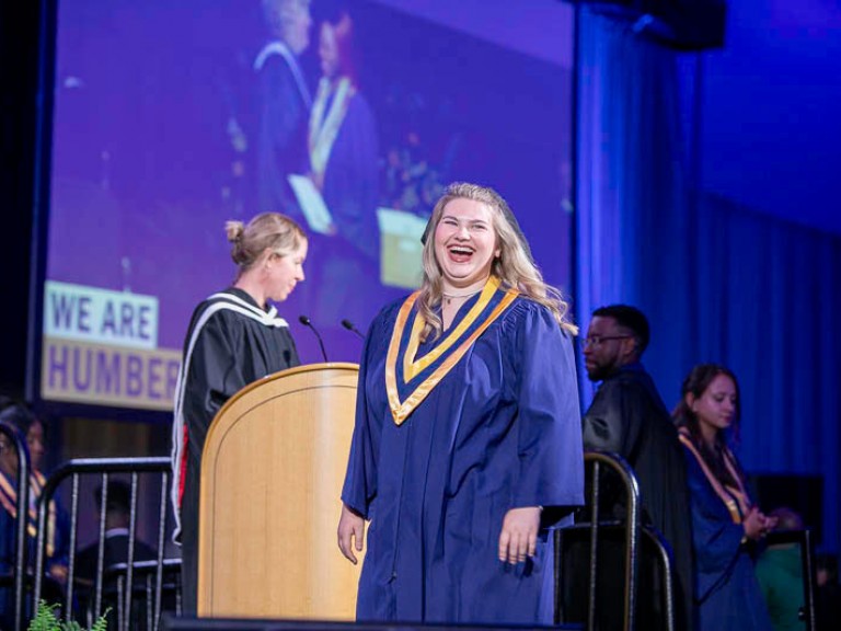 Graduate smiles as they cross stage