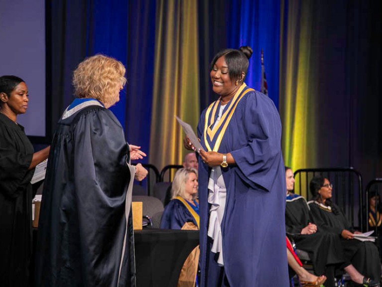 Graduate smiles at Humber president on stage