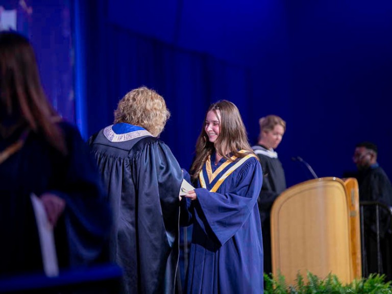 Graduate accepts certificate from Humber president