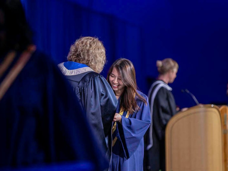 Graduate on stage with Ann Marie Vaughan