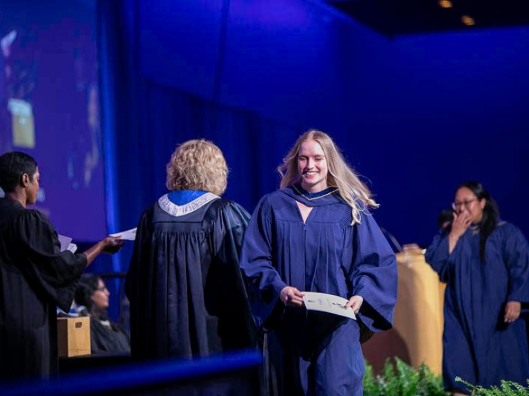 Graduate leaves the stage with their certificate