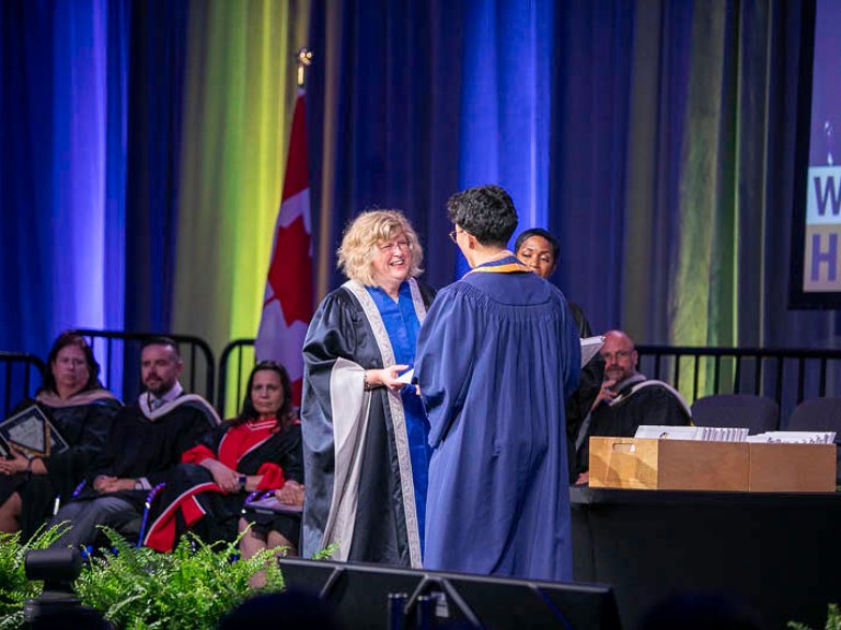 Ann Marie Vaughan smiles at graduate on stage
