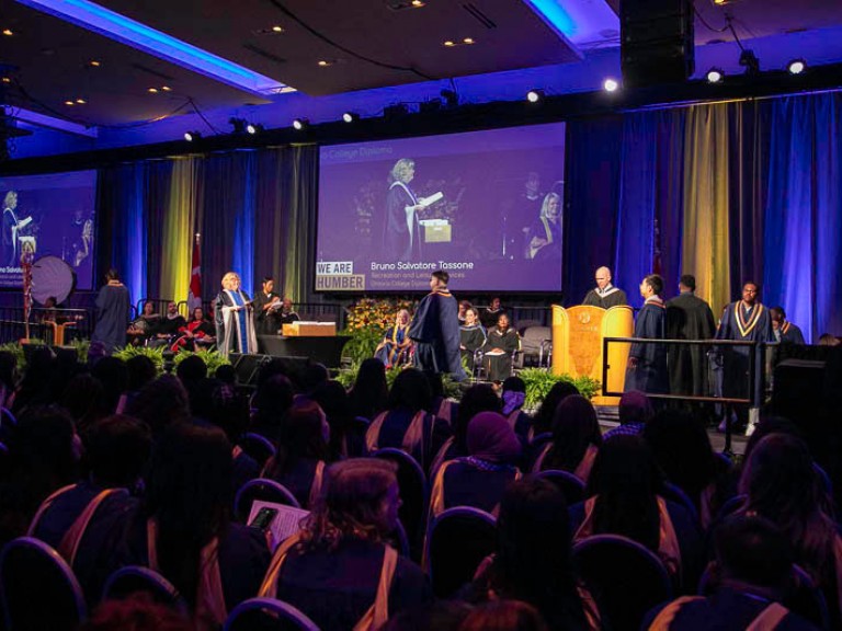 Graduate crosses the stage to meet Humber president