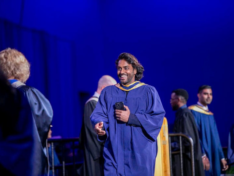 Graduate crosses stage to receive their credential