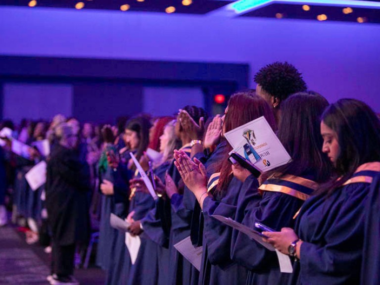 Graduates in audience clapping