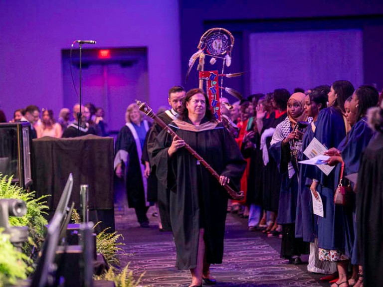 Humber faculty proceed in line through hall