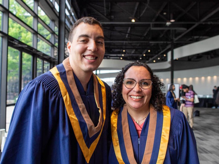 Two graduates smile for camera