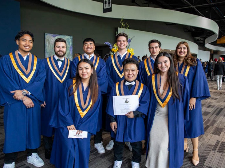 Nine graduates smile for photo