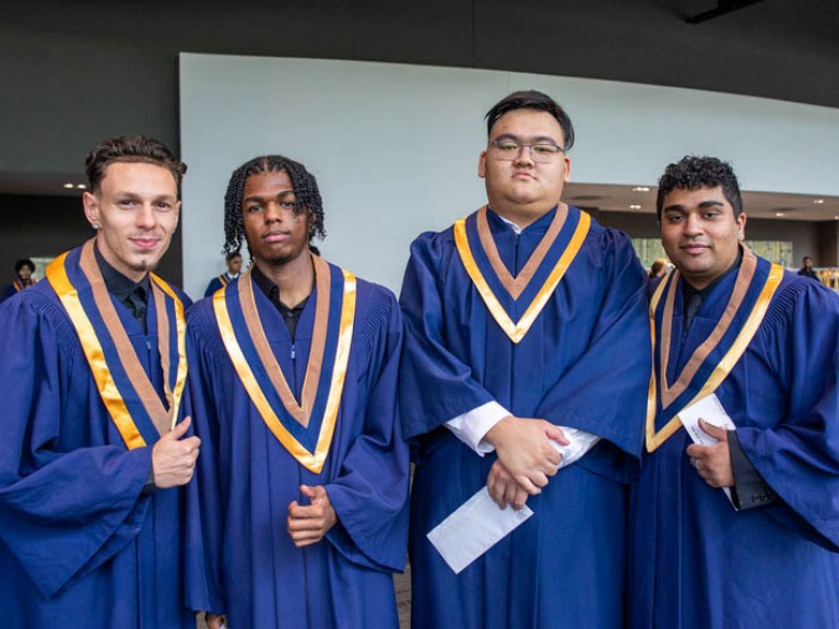 Four graduates pose for photo