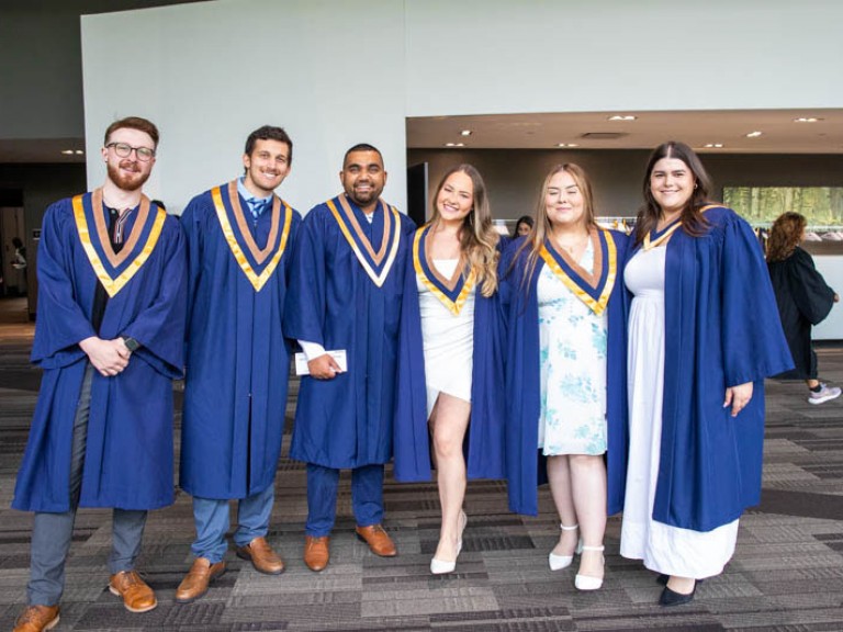 Six graduates pose for camera