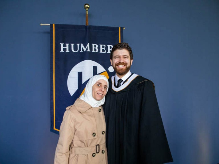 Honorary degree recipient Tareq Hadhad takes photo with a guest