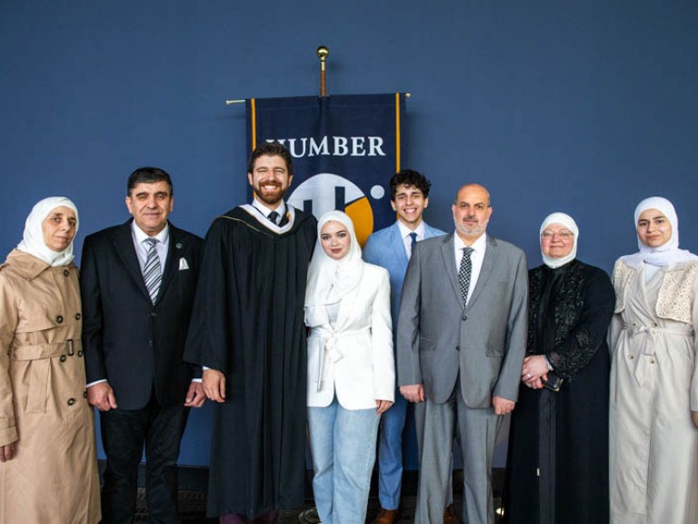 Honorary degree recipient Tareq Hadhad takes photo with ceremony guests