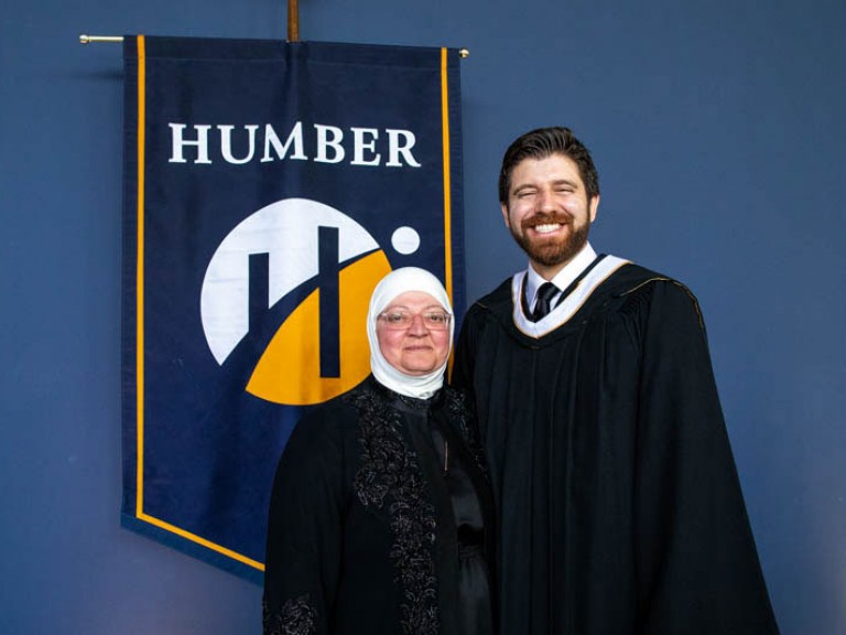 Honorary degree recipient Tareq Hadhad takes photo with ceremony guest