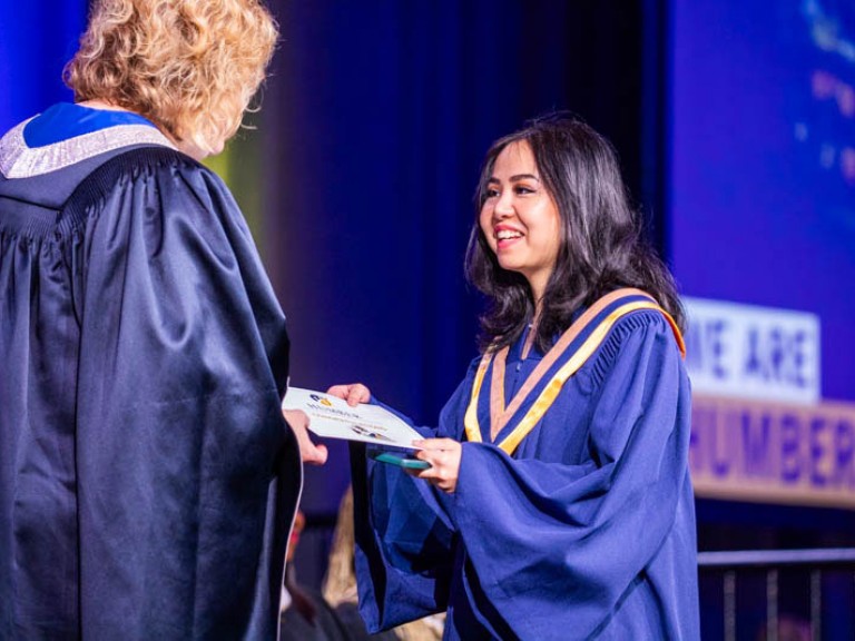 Graduate accepts their credential on stage