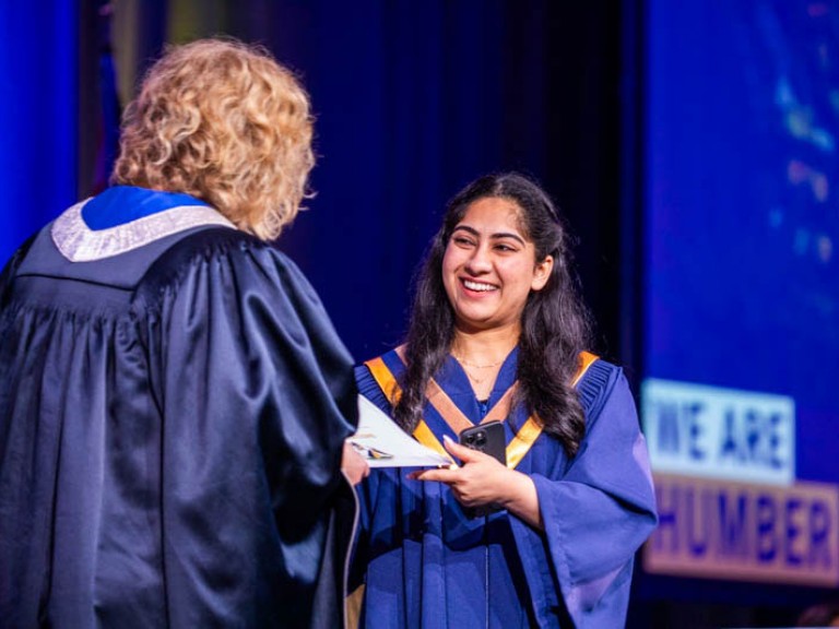 Graduate accepts their credential on stage