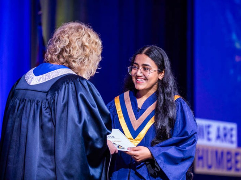 Graduate accepts their certificate on stage