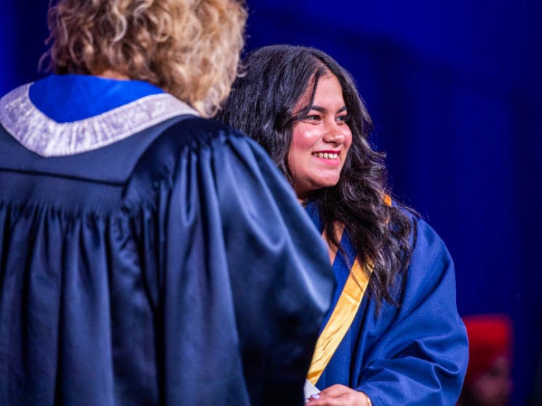 Graduate smiles towards audience